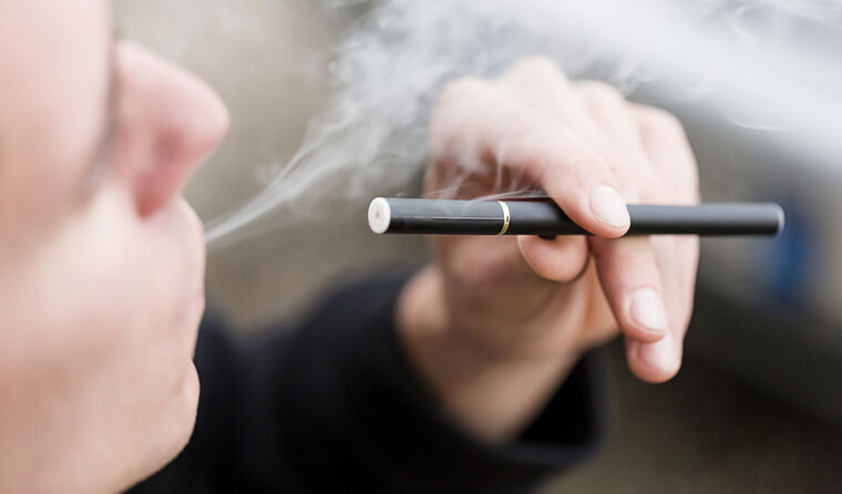 Young person smoking an e-cigarette.