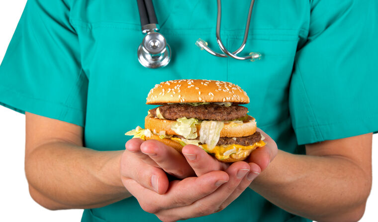 Doctor holding a hamburger.