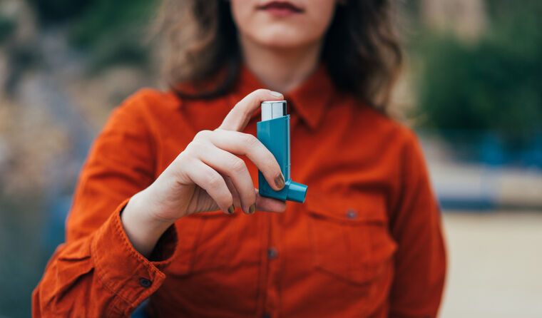 Woman holding an asthma puffer.