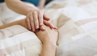 A person holding hands with a patient