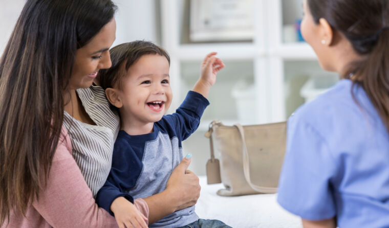Doctor helping a mother and laughing child.