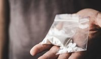Close up of hands holding bags of stimulant drugs