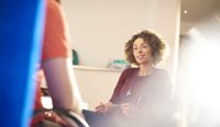 Young female doctor sits opposite patient.