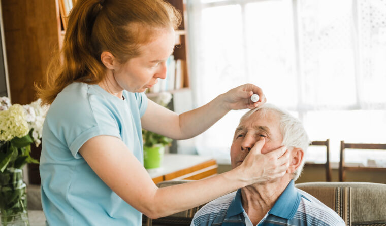 Woman giving man eye drops.