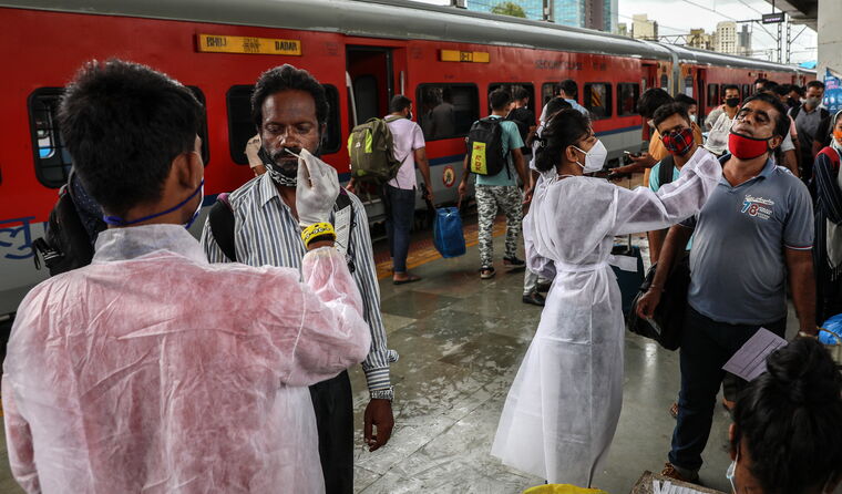 Indian people getting a COVID test a train station