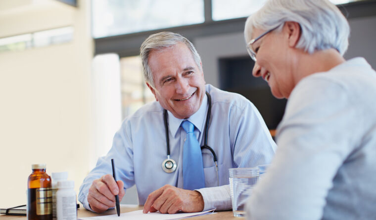 Older GP talking to patient.