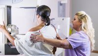 Doctor helping a woman get a mammogram.