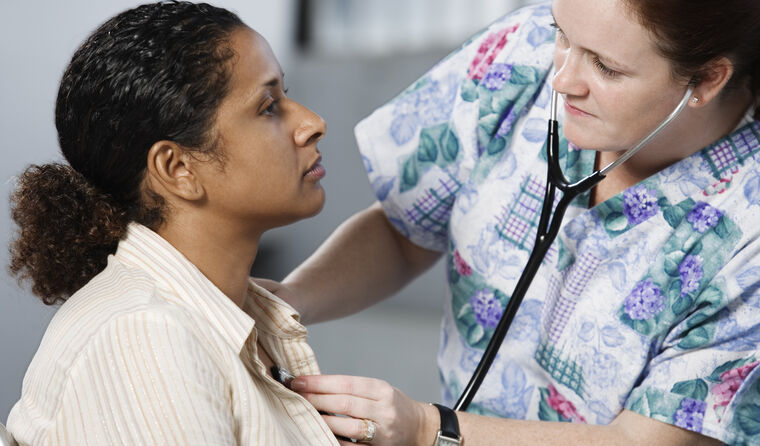 GP checking patient's heart with a stethoscope