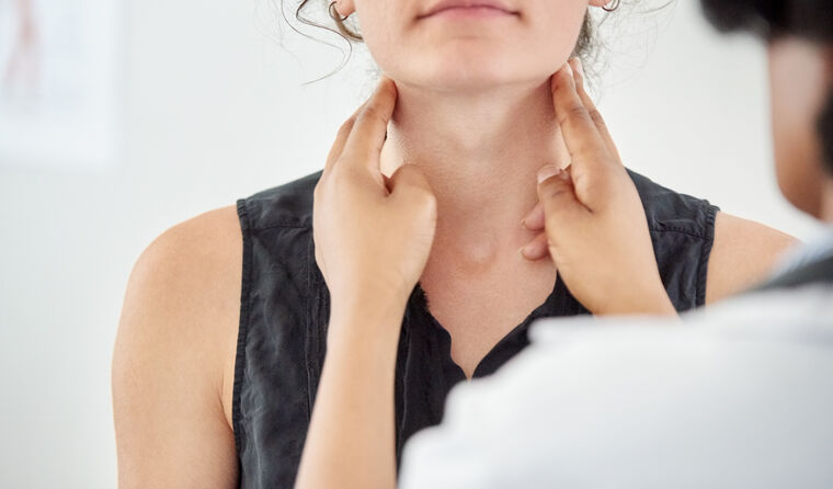 GP checking woman's thyroid 