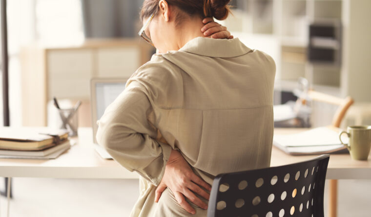 Woman holding neck in pain.