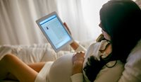 Pregnant woman looking at iPad