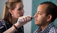 A female GP assessing a male patient’s ear health.
