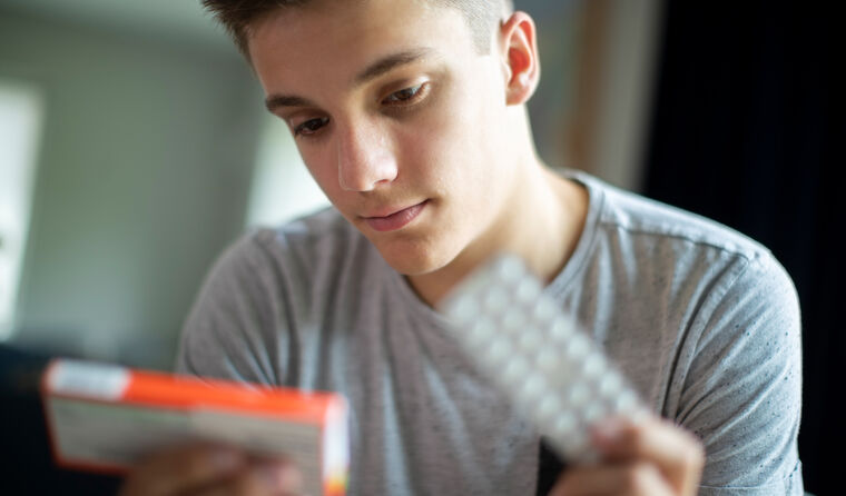 Young man looking at antidepressant medication.