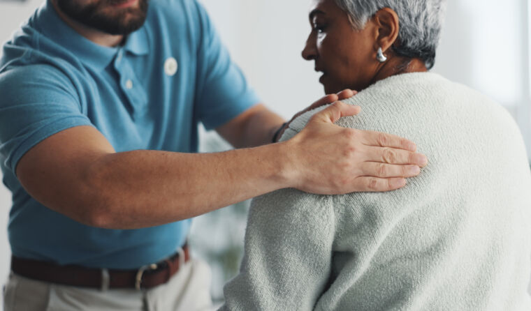 GP examining patient for shoulder pain