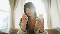 A person looking at medication label.