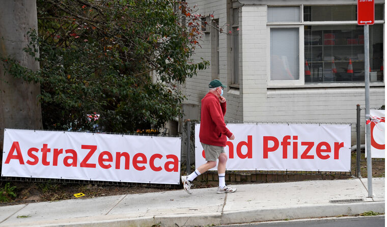 A man walking past a banner.