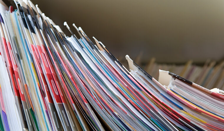 An image of a group of paper files on a shelf.
