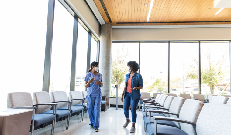 Nurse talking to patient in a waiting room.