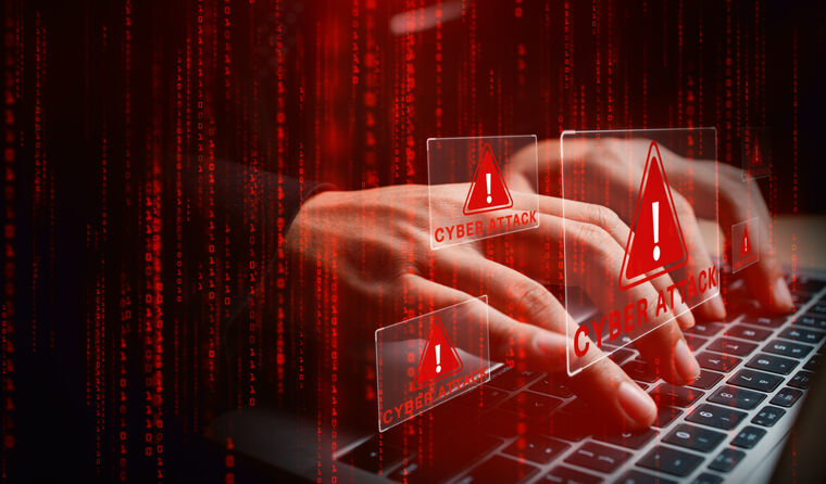 A person on a computer with cyber warning graphic