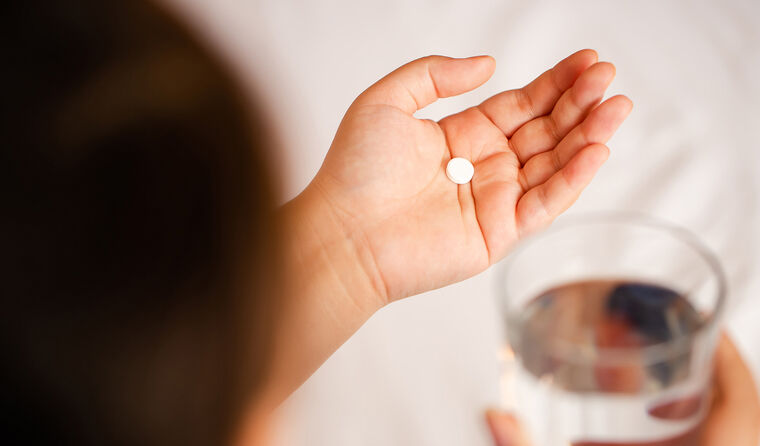Woman taking opioid tablet