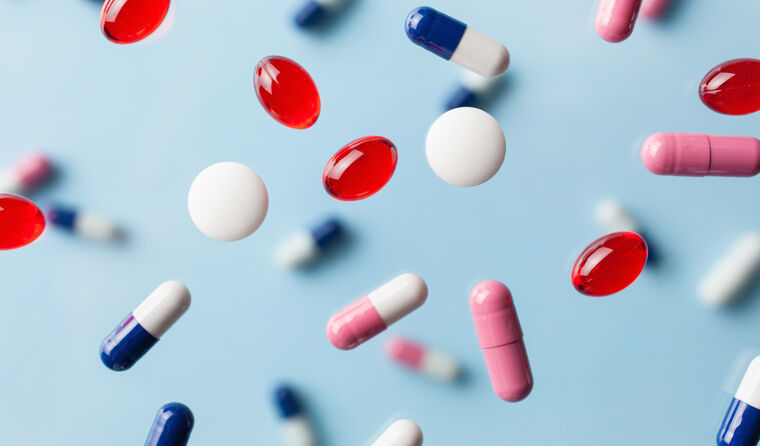 Kleurrijke capsules en pillen vallen naar beneden.