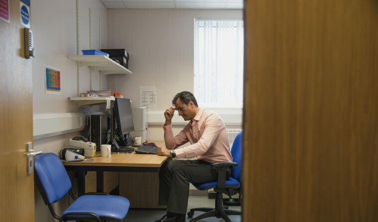 GP in his office looking worried