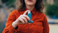 Woman holding an asthma puffer.