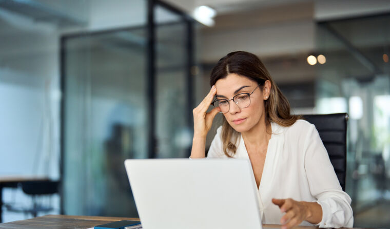 A female doctor looking stressed at computer
