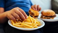 Young overweight person eating junk food