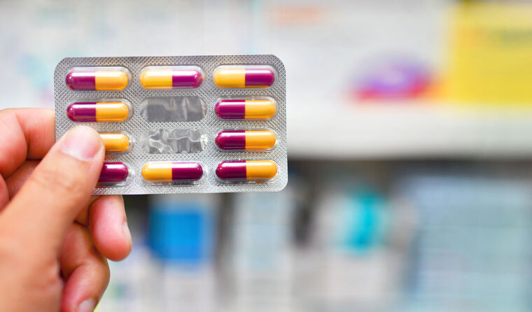 Pharmacist holding blister pack of antibiotics.
