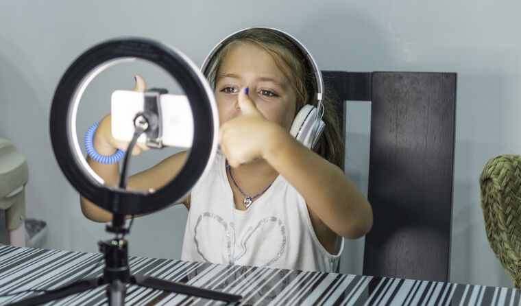 Young blonde girl making social media content.