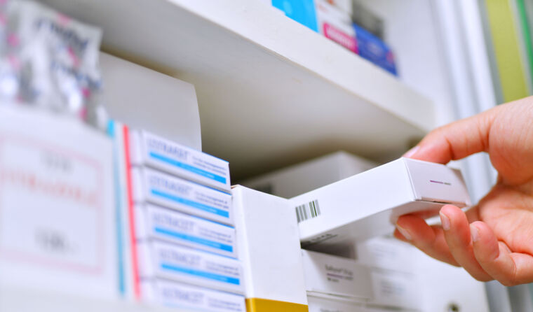 Hand grabbing medication off shelf.