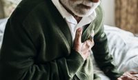Elderly man clutching his chest.