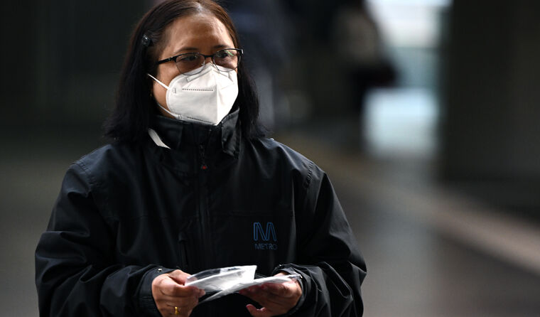 A worker handing out N95 masks 