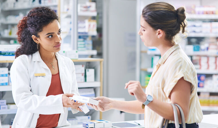 Pharmacist helping patient with prescription.
