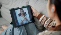 Young woman in telehealth consult on laptop