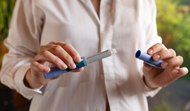 A woman opens an GLP-1 injectable.