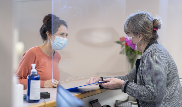 A receptionist welcoming a female patient.