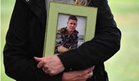 Julie-Ann Finney holds a framed photograph of her son at a rally to protest veteran suicide outside Parliament House in Canberra. (Image: AAP)