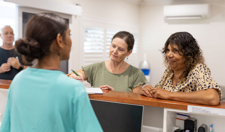 GP receptionist talking to patient.