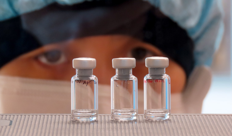 Researcher looking at vials
