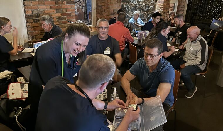Men in a pub getting blood and heart checks.