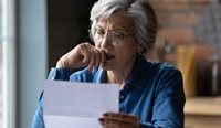 Concerned woman looking at letter 