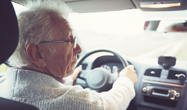 An elderly person driving.