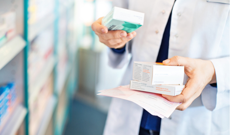 A pharmacist holding boxes of medication. 