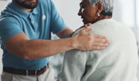 GP examining patient for shoulder pain