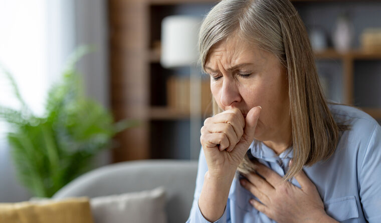 A older woman coughing.