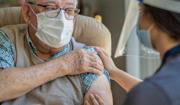 Elderly man receiving a vaccine.