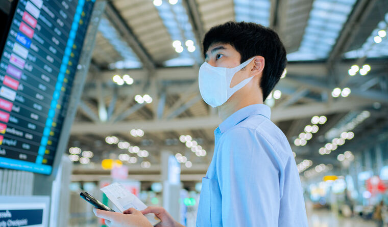Man at airport wearing face mask.