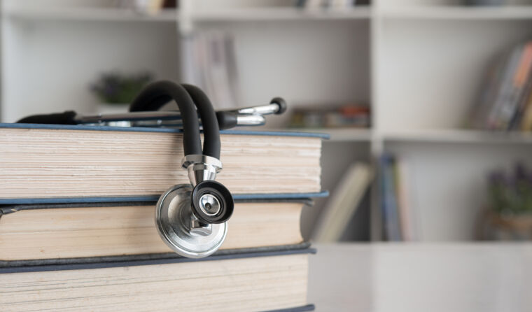 Stethoscope sitting on a pile of books.